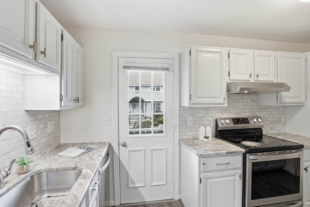 425 Main Street, Unit 22C Hudson, MA 01749 - Photo 7 of 23 a kitchen with stainless steel appliances granite countertop a stove a sink and a white cabinets