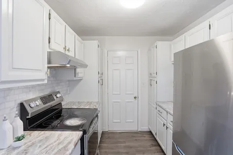a kitchen with cabinets and a stove top oven