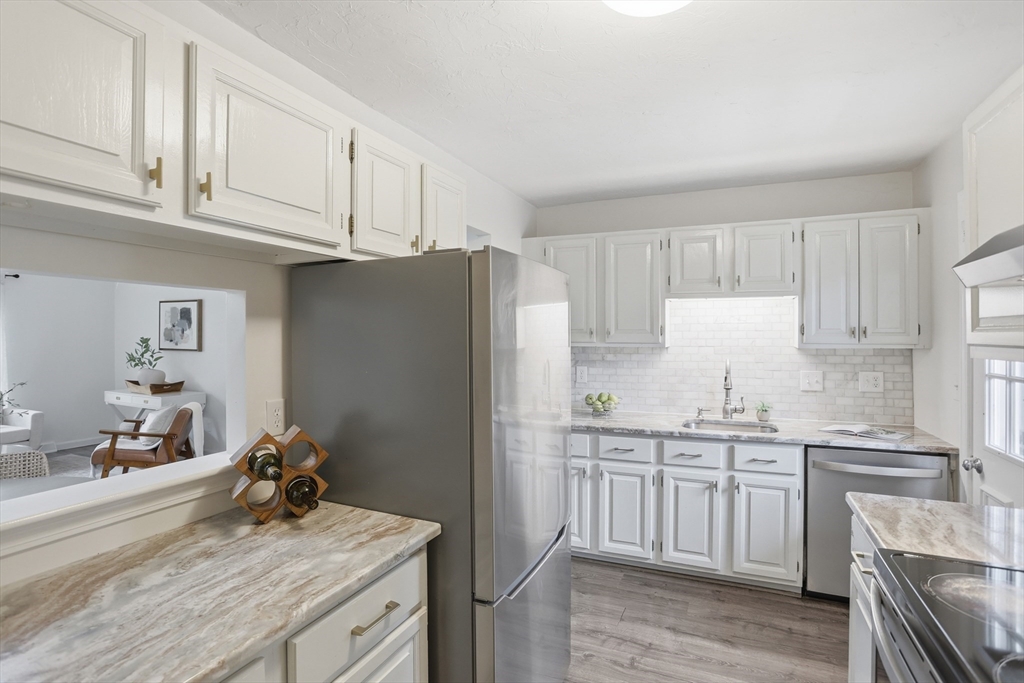 425 Main Street, Unit 22C Hudson, MA 01749 - Photo 9 of 23 a kitchen with a sink a stove a refrigerator and cabinets