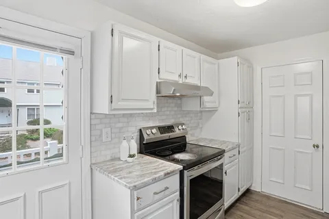 a kitchen with a stove and a white cabinet