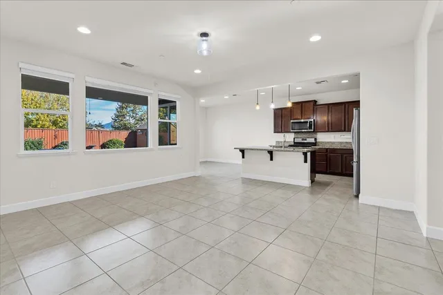 a kitchen with stainless steel appliances granite countertop a sink refrigerator and cabinets