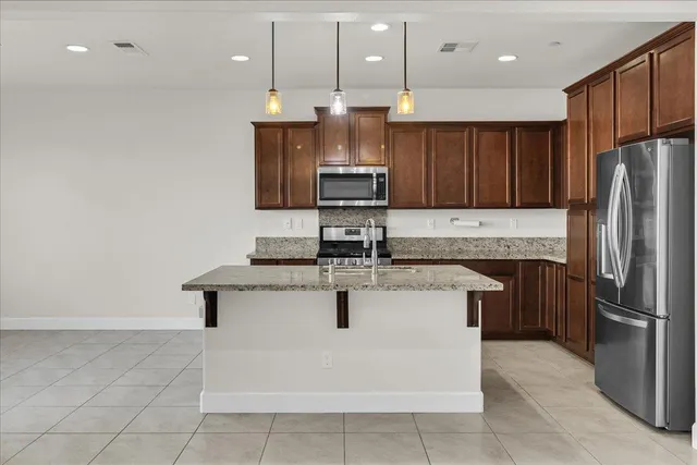a kitchen with stainless steel appliances granite countertop a sink a stove and a refrigerator