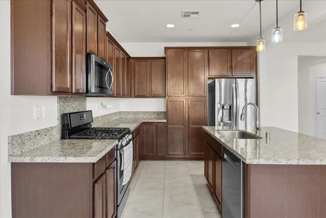 a kitchen with stainless steel appliances granite countertop a sink stove and cabinets