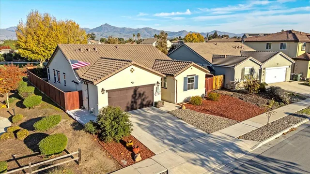 a view of a big house with a big yard and large tree