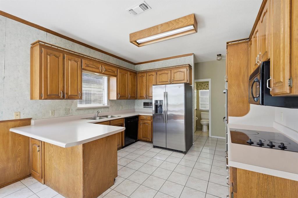 211 Bayne Road Haslet, TX 76052 - Photo 9 of 29 a kitchen with a refrigerator and a sink