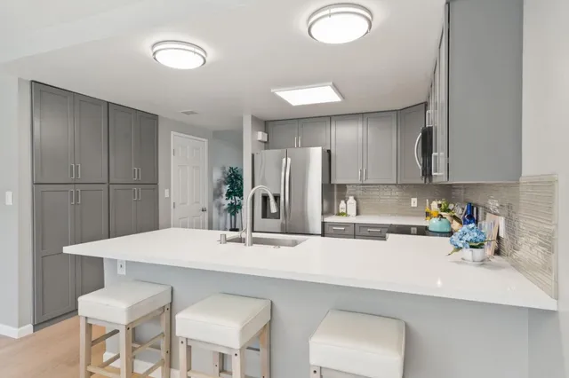 a kitchen with a sink cabinets and chairs