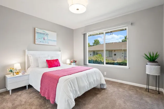 a bedroom with a bed potted plant and a window