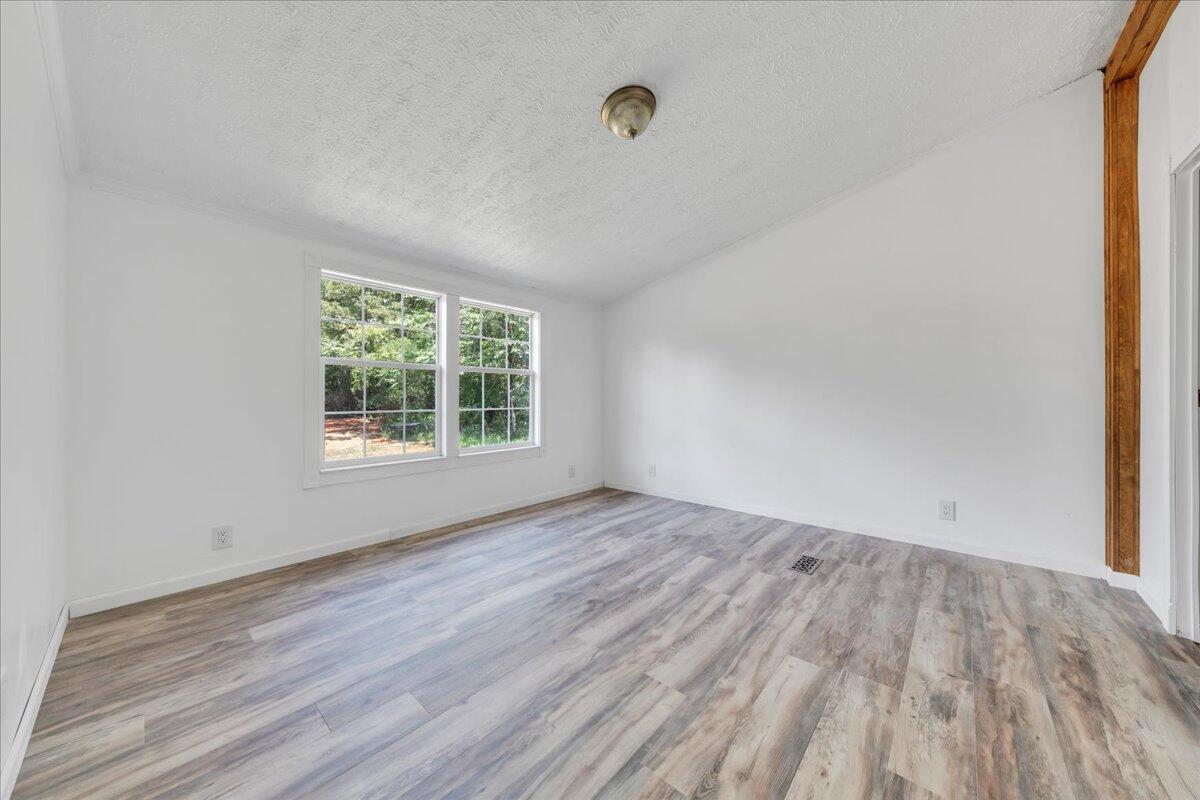 6638 Stewartsville Road Moneta, VA 24121 - Photo 13 of 27 an empty room with wooden floor and windows