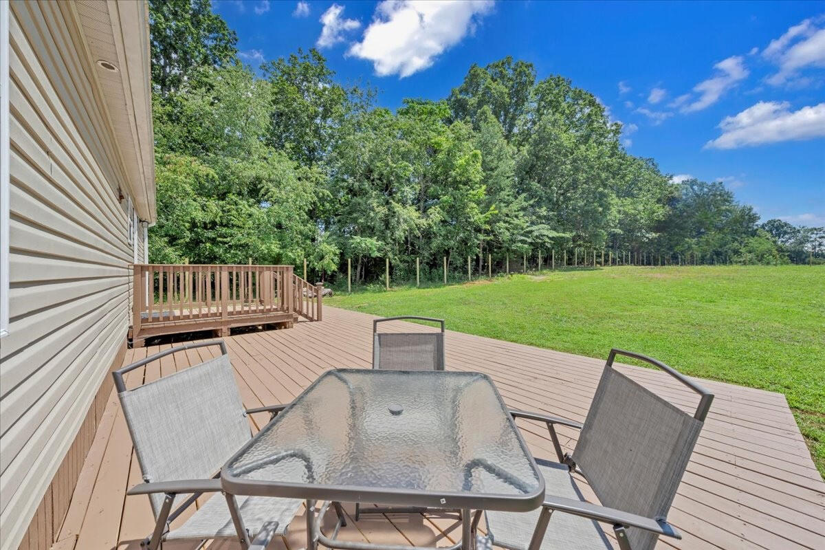 6638 Stewartsville Road Moneta, VA 24121 - Photo 20 of 27 a view of a patio with table and chairs and potted plants with wooden floor and fence