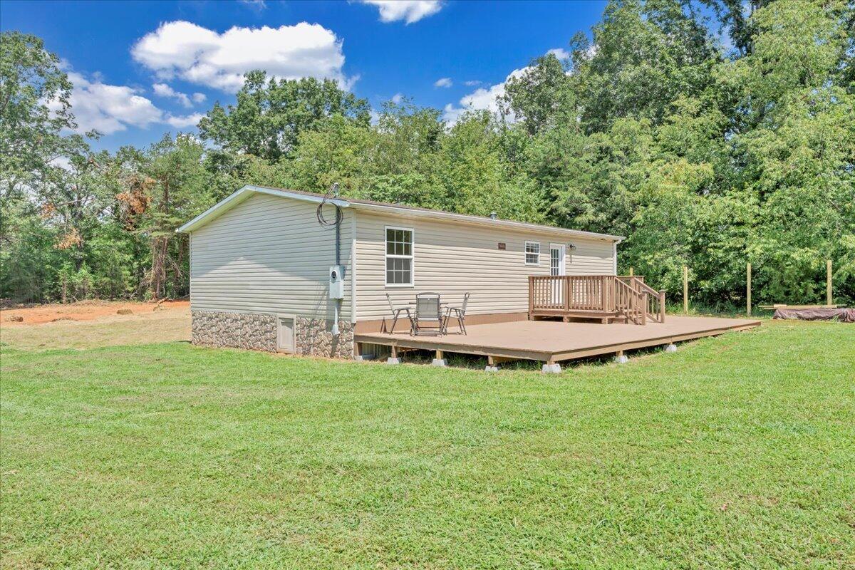 6638 Stewartsville Road Moneta, VA 24121 - Photo 25 of 27 a white house with a small yard and large trees
