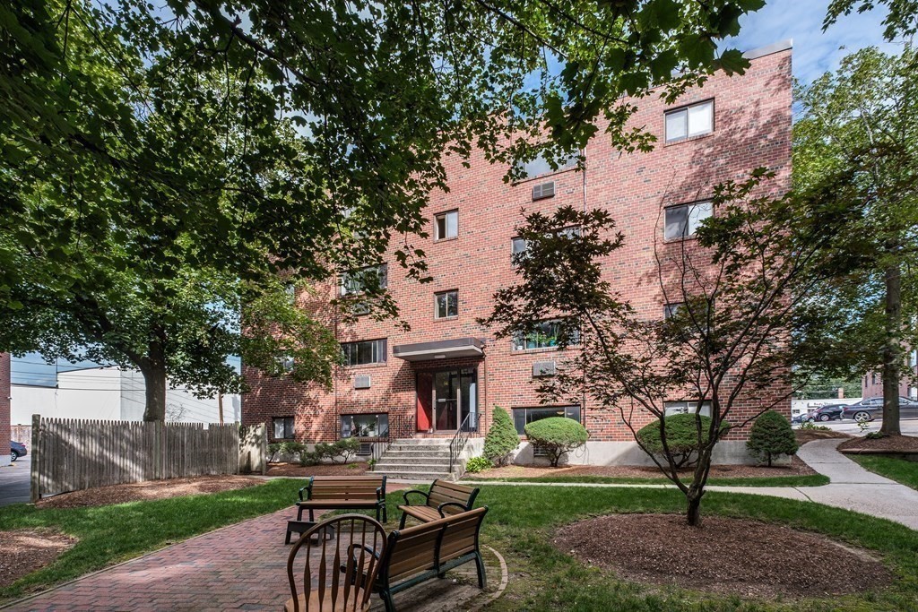 14 Riverside Street, Unit G3 Watertown, MA 02472 - Photo 13 of 18 a view of a patio with table and chairs and a fire pit