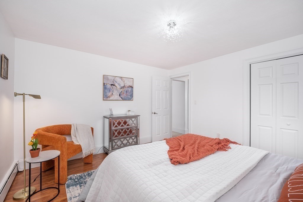 14 Riverside Street, Unit G3 Watertown, MA 02472 - Photo 6 of 18 a bedroom with a bed and dresser with wooden floor