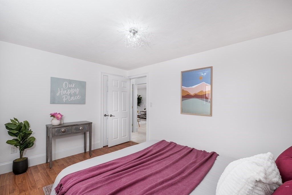 14 Riverside Street, Unit G3 Watertown, MA 02472 - Photo 8 of 18 a bedroom with a bed and a chandelier