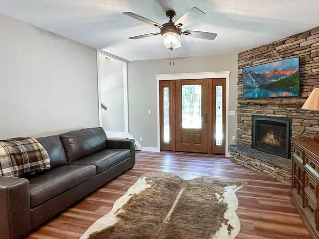 a living room with furniture a flat screen tv and a fireplace