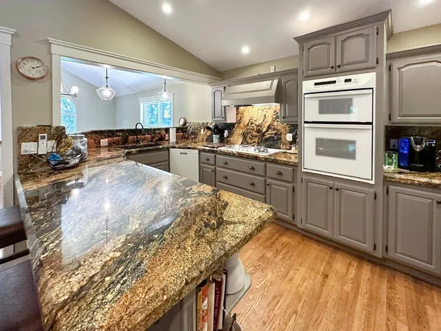 a kitchen with stainless steel appliances granite countertop a stove and a sink
