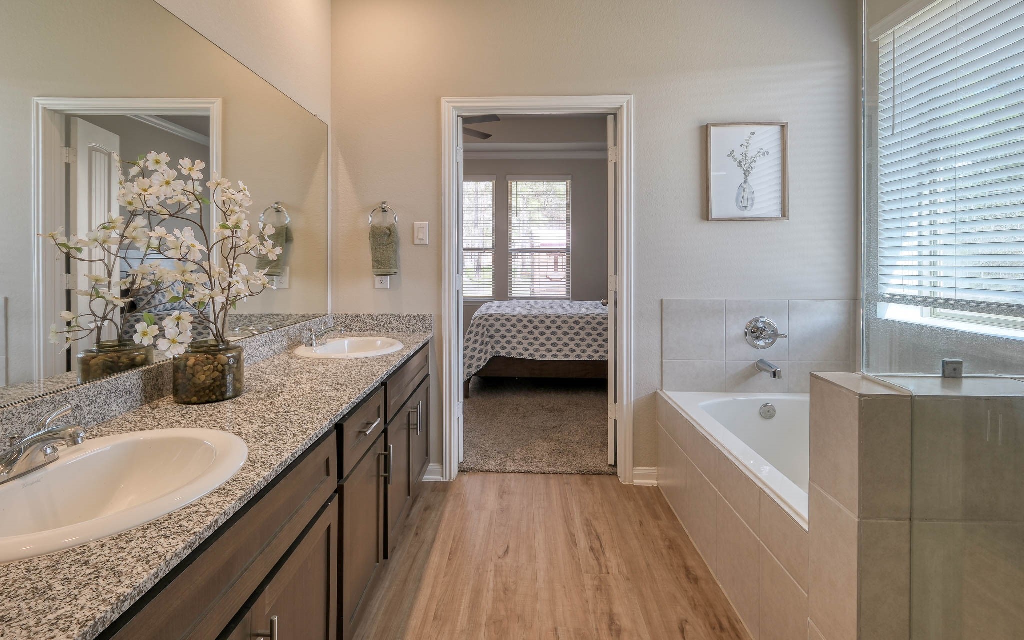 16747 Rockwall Street Conroe, TX 77303 - Photo 27 of 50 Large Primary Bathroom features soaker tub and separate walk-in shower. Double sinks make getting ready for the day a breeze! Front to back, this .99 acre has so many possibilities and awaits your imagination. 16747 Rockwall St, 77303 features .9 partially cleared acre, stone and brick home built in 2023. Well cared for, and ready to grow your dreams!