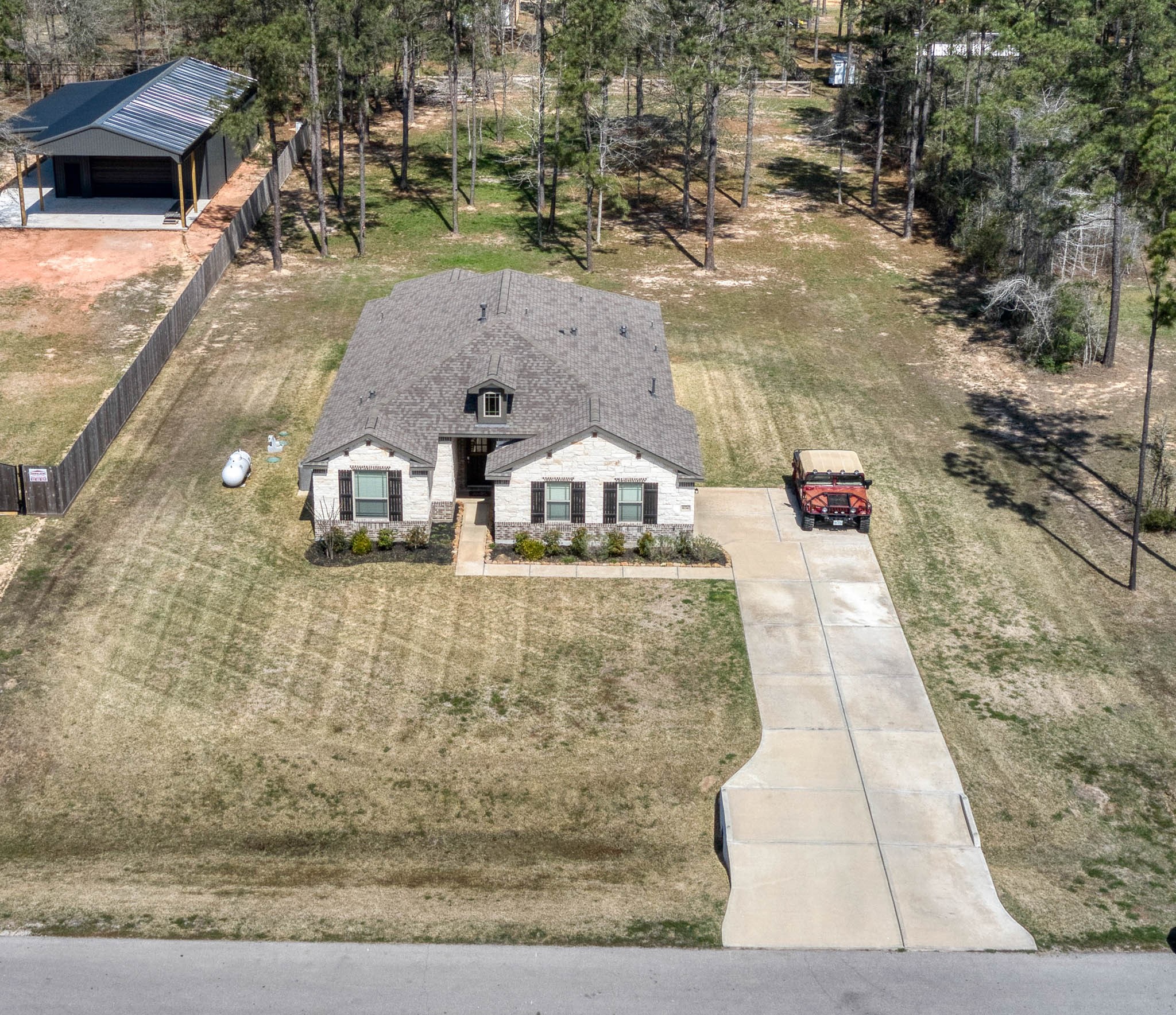 16747 Rockwall Street Conroe, TX 77303 - Photo 7 of 50 Aerial view! DIGITALLY STAGED to spark the imagination -- front to back, this entire .99 acre has so many possibilities and awaits your imagination. 16747 Rockwall St, 77303 features .9 partially cleared acre, stone and brick home built in 2023. Well cared for, and ready to grow your dreams!