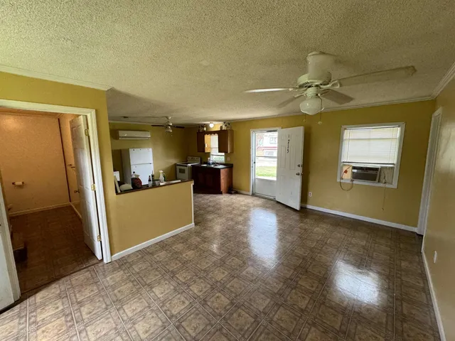 a view of a livingroom with wooden floor and a kitchen