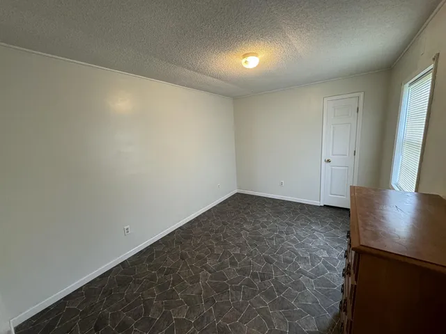 an empty room with wooden floor and window