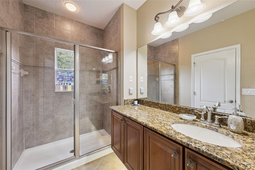607 Pensacola Lane Lake Mary, FL 32746 - Photo 13 of 35 a bathroom with a granite countertop double vanity sink mirror and shower