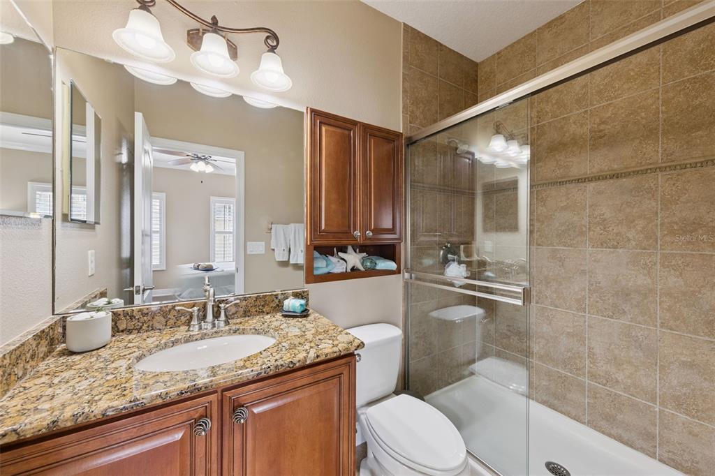 607 Pensacola Lane Lake Mary, FL 32746 - Photo 18 of 35 a bathroom with a granite countertop sink a mirror a toilet and shower