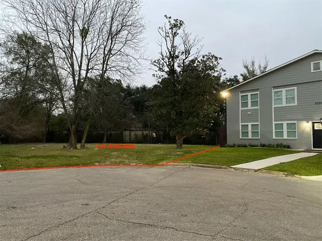 a view of a house and a yard and large trees