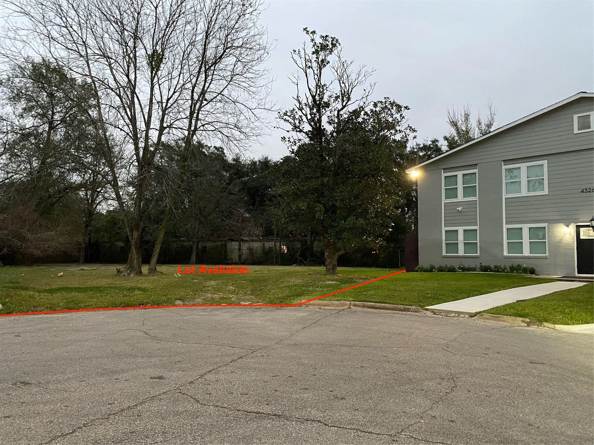 a view of a house and a yard and large trees