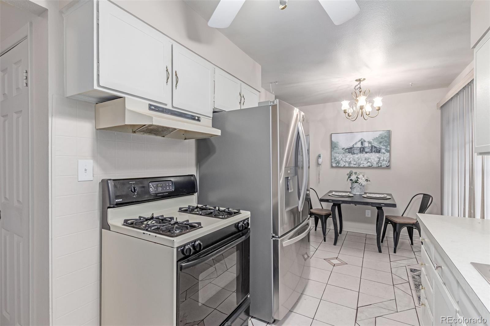 1285 Elder Street Denver, CO 80221 - Photo 12 of 35 a kitchen with granite countertop a stove a refrigerator and a dining table
