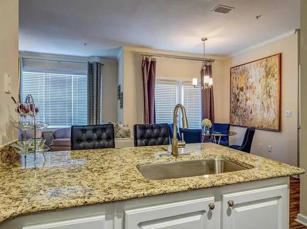 a kitchen with a granite countertop sink and a large mirror