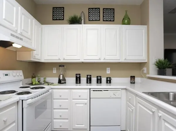a kitchen with white cabinets and white appliances