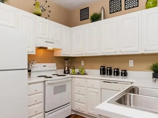 a kitchen with white cabinets and white appliances
