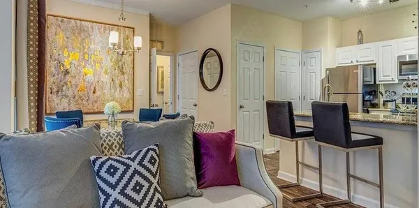 a living room with furniture a chandelier a fireplace and a large window