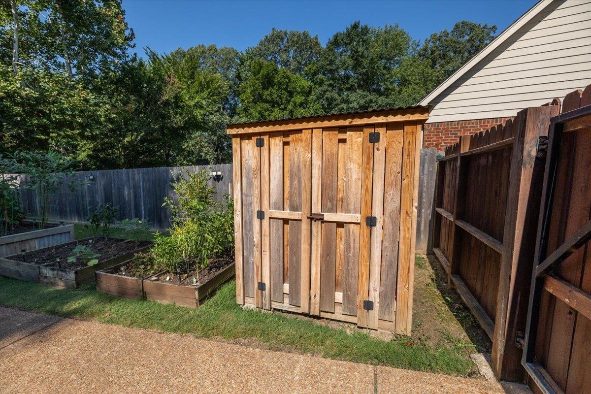 8523 Bazemore Road Memphis, TN 38018 - Photo 36 of 40 a view of a backyard with potted plants and wooden fence