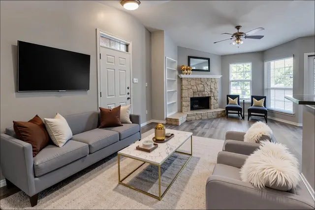a living room with furniture a fireplace and a flat screen tv