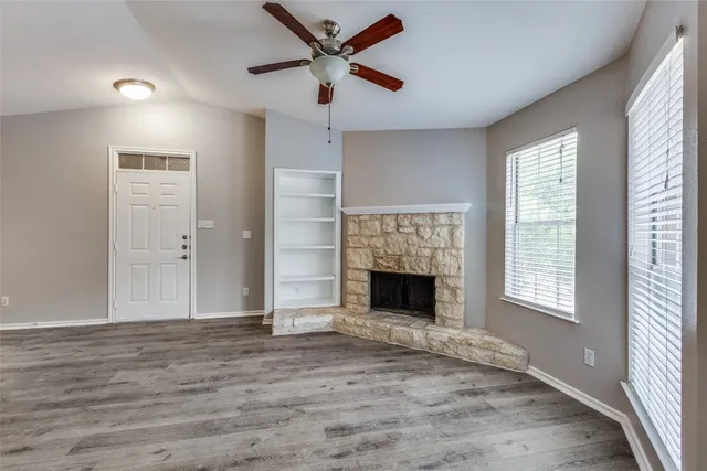 a view of empty room with fireplace and wooden floor