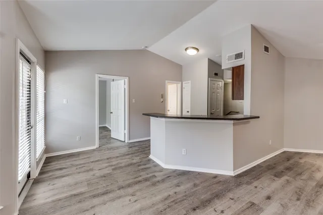 a view of a kitchen with cabinets and wooden floor