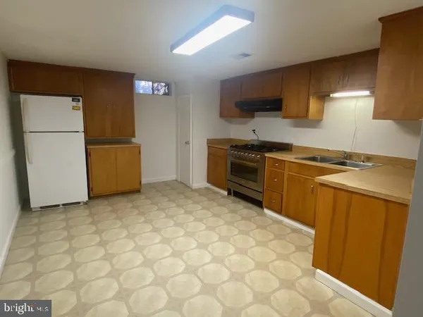 a kitchen with stainless steel appliances granite countertop a refrigerator sink and stove