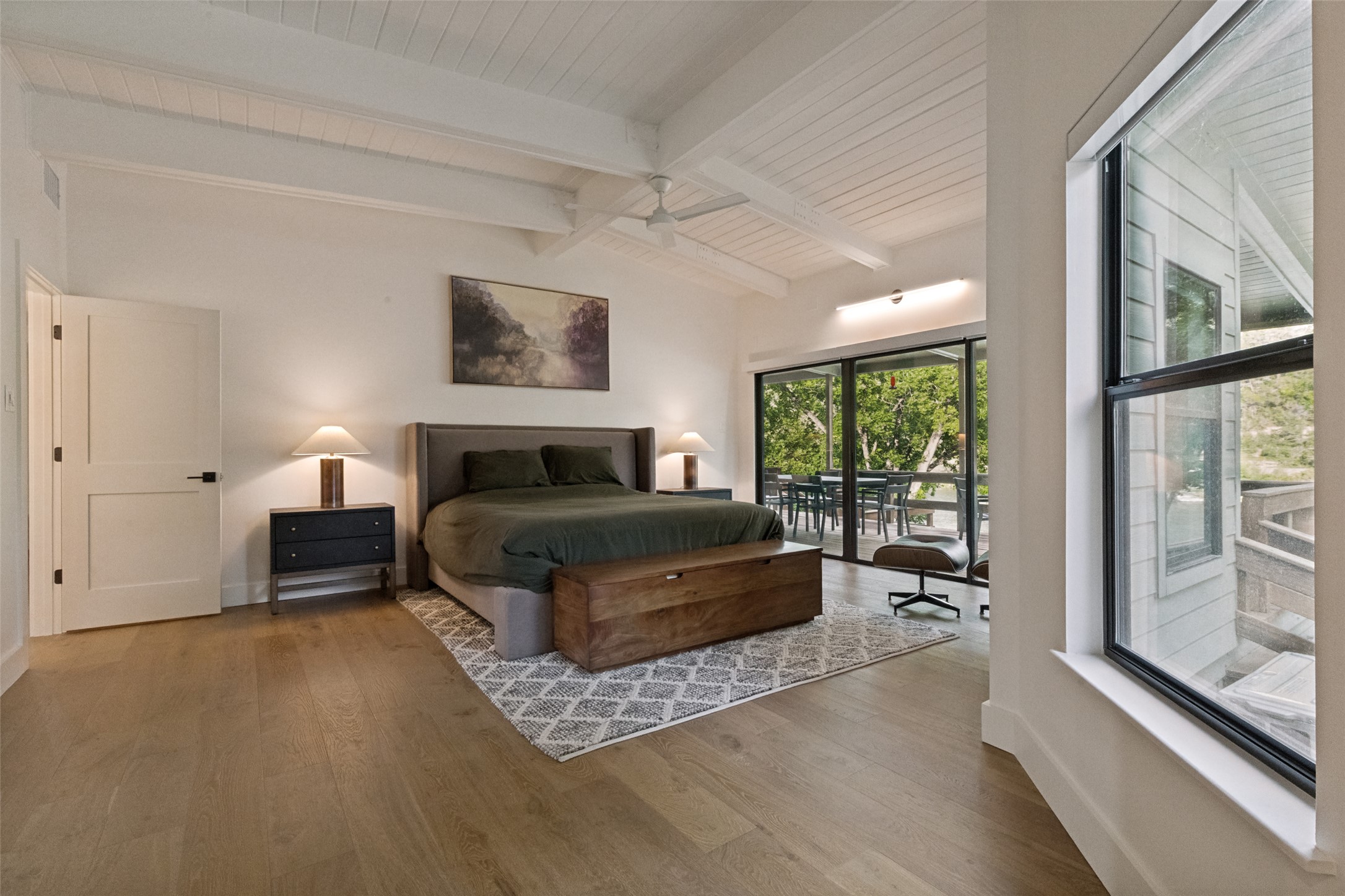 303 Lago Verde Road Austin, TX 78734 - Photo 17 of 39 Hardwood flooring extends throughout this naturally illuminated bedroom with exposed beam ceilings and direct deck access.