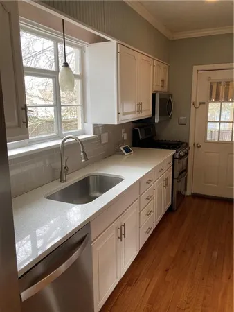a kitchen with stainless steel appliances granite countertop a sink a stove and a refrigerator