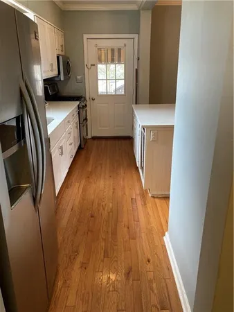 a kitchen with wooden floor and a window