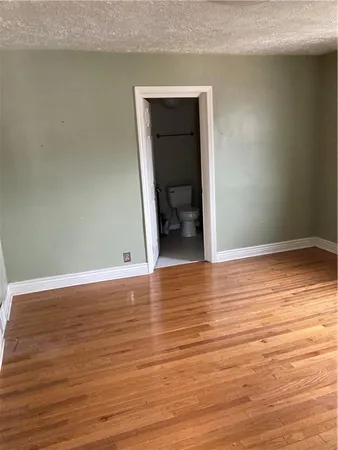 an empty room with wooden floor and closet