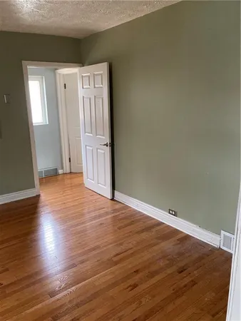 an empty room with wooden floor and closet