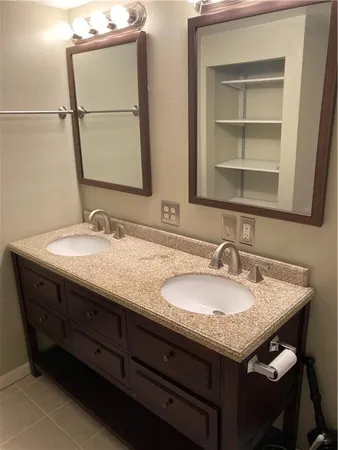 a bathroom with a granite countertop sink and a mirror