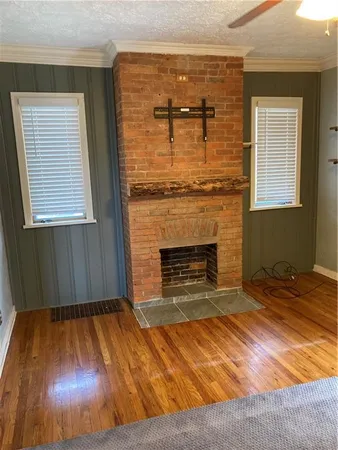 a view of a livingroom with wooden floor and a fireplace