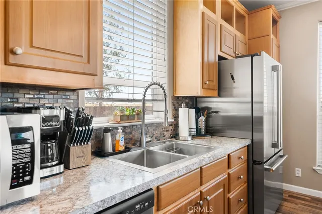 a kitchen with stainless steel appliances granite countertop a sink and a refrigerator