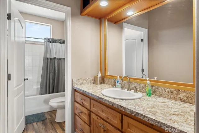 a bathroom with a granite countertop sink toilet and shower
