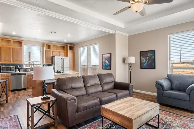 a living room with furniture kitchen view and a window