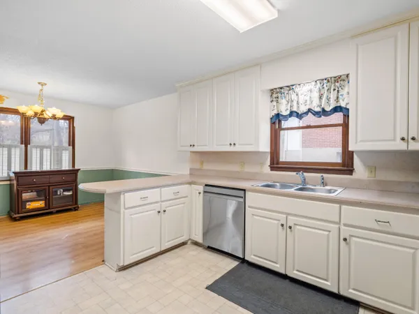 a kitchen with white cabinets and refrigerator