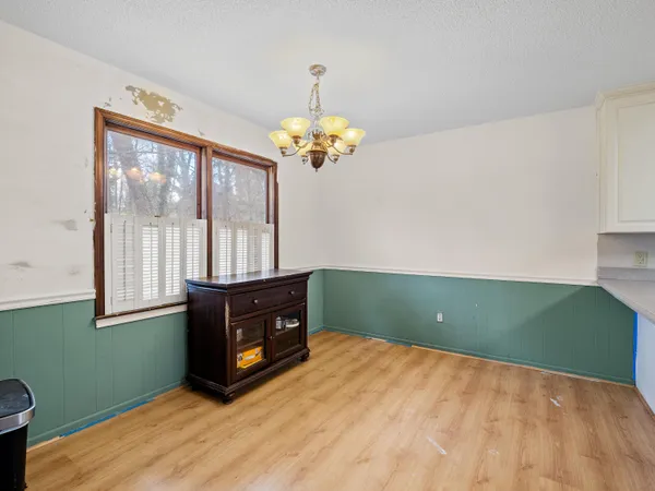 a spacious bedroom with a bed and a chandelier