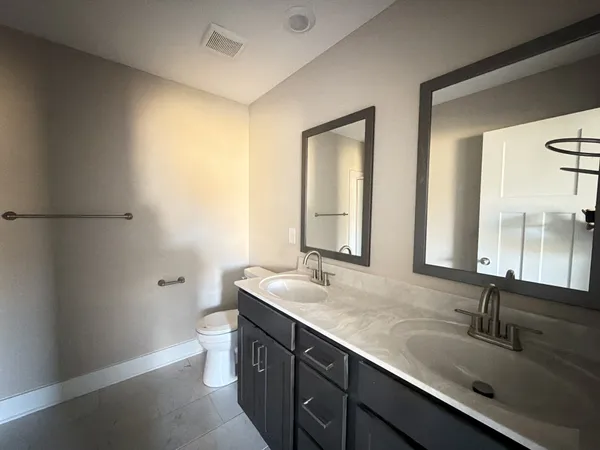 a bathroom with a sink a toilet and mirror